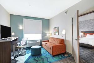 グランドジャンクショ​​ンにあるHome2 Suites By Hilton Grand Junction Northwestのベッド、デスク、椅子が備わるホテルルームです。