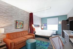 大章克申Home2 Suites By Hilton Grand Junction Northwest的配有床和沙发的酒店房间