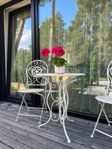 stół i krzesła na ganku z kwiatami w obiekcie Park Apartments w mieście Kulautuva