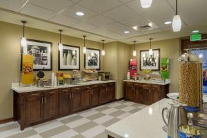 a restaurant with wooden cabinets and a food counter at Hampton Inn & Suites Portland/Vancouver in Vancouver