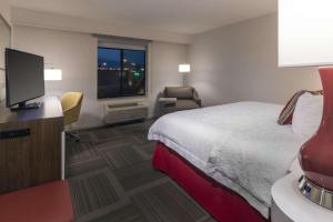 a hotel room with a bed and a flat screen tv at Hampton Inn Lehi-Thanksgiving Point in Lehi