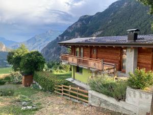 a wooden house with a balcony and mountains in the background at Chalet Gorret in Torgnon