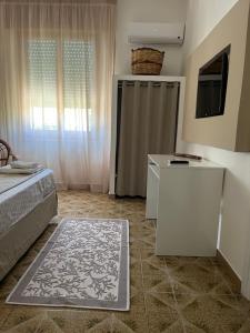 a bedroom with a bed and a television and a rug at Villa Zagara in Marsala