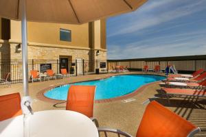 a pool at a hotel with orange chairs and tables at Hampton Inn Temple in Temple