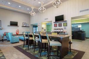 a restaurant with a long bar with chairs and tables at Hampton Inn and Suites Adairsville/Calhoun Area in Adairsville