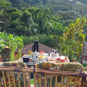 - une table avec un service à thé sur le balcon dans l'établissement Recanto Casa Amarela de São Romão, à Nova Friburgo