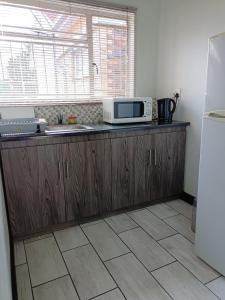 a kitchen with a counter top with a microwave at 21 On Coetzee Guest House in Bloemfontein