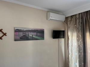 ein Zimmer mit einem Bild eines Piers an der Wand in der Unterkunft DEL MAR APARTMENTS I in Agía Triás