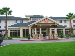 Hilton Garden Inn Redding في ريدينغ: مبنى كبير أمامه أشجار نخيل