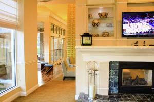 a living room with a fireplace with a tv above it at Hilton Garden Inn Redding in Redding