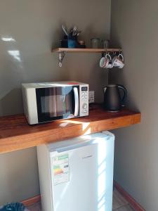 un microondas sentado en un mostrador junto a una nevera en 21 On Coetzee Guest House en Bloemfontein