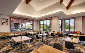 a restaurant with tables and chairs and windows at Hilton Garden Inn Bozeman in Bozeman