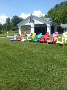 a row of colorful chairs sitting in a yard at Carolina Motel in Franklin