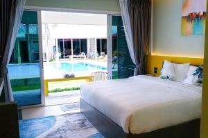 1 dormitorio con cama y vistas a la piscina en Maiiam Bungalows Kata Beach en Kata Beach
