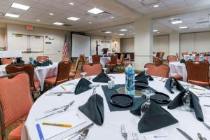 einen Konferenzraum mit weißen Tischen und Stühlen in der Unterkunft Hilton Garden Inn Denver Airport in Aurora