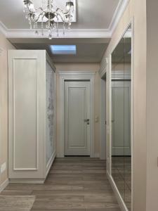 a hallway with a door and a chandelier at Apartament in the center of Chisinau in Chişinău