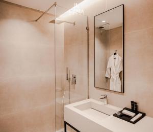 a bathroom with a sink and a shower with a mirror at La Onda Hotel Durres in Durrës