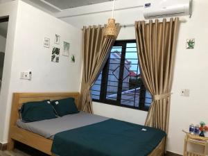 1 dormitorio con cama y ventana en Xuka Homestay en Hue