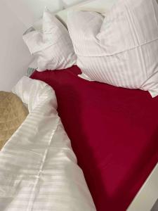 ein unmaskiertes Bett mit weißen Kissen und einer roten Decke in der Unterkunft Stylish Studio Near Orhideea Towers W Free Wifi in Bukarest