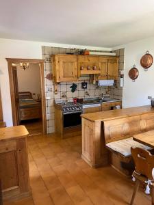 a kitchen with wooden cabinets and a stove at Appartamento Pelmo in San Vito di Cadore