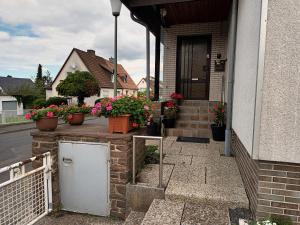 a porch with potted plants and flowers on a house at Ferienwohnung Kassel in Kassel
