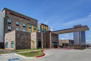 Un gran edificio de ladrillo con un cartel delante. en Hilton Garden Inn Topeka, en Topeka