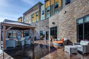 een patio met banken en stoelen voor een bakstenen gebouw bij Hilton Garden Inn Topeka in Topeka