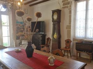 ein Wohnzimmer mit einem Tisch und einer Großvater-Uhr in der Unterkunft Gîte du château de Chevannes in Amazy