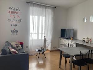 ein Wohnzimmer mit einem Sofa und einem Tisch mit Stühlen in der Unterkunft Casa Mirella in Lovere