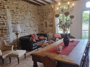 sala de estar con mesa de madera y pared de ladrillo en Gîte du château de Chevannes, en Amazy