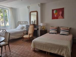 1 Schlafzimmer mit 2 Betten und einem Spiegel in der Unterkunft Gîte du château de Chevannes in Amazy