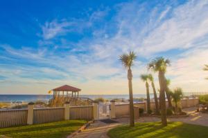 uma vista para a praia com palmeiras e um gazebo em Hilton Pensacola Beach em Pensacola Beach