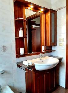 ein Bad mit einem Waschbecken und einem Spiegel in der Unterkunft La Rocconella in Arten