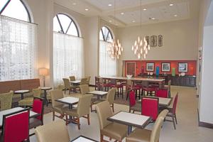 a dining room with tables and chairs and windows at Hampton Inn Schenectady Downtown in Schenectady