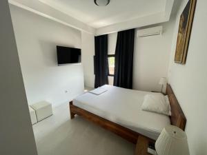 a white bedroom with a bed and a window at Noce Zagreb in Zagreb