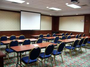 una sala conferenze con tavoli, sedie e schermo di Homewood Suites by Hilton Brighton a Brighton