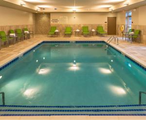 a pool in a hotel room with chairs and tables at Hampton Inn & Suites New Albany Columbus in New Albany
