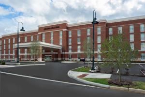 a large red brick building with a road in front of it at Hampton Inn & Suites New Albany Columbus in New Albany