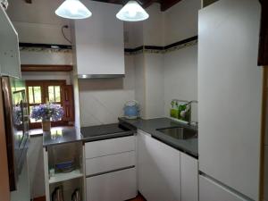 una cocina con armarios blancos y encimeras negras en Casa Rural La Santa, en Sorribas