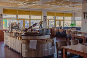 a restaurant with a bar and tables and chairs at Hotel de Boegschroef in Delfzijl