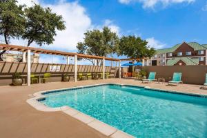a swimming pool at a hotel with chairs and tables at Home2 Suites by Hilton DFW Airport South Irving in Irving