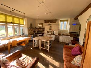a kitchen and living room with a table and chairs at Ash Barton - Big Party House, No Curfew! in Wrafton