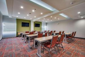 una sala de conferencias con mesas, sillas y una pantalla en Home2 Suites by Hilton DFW Airport South Irving en Irving