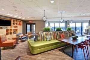 un soggiorno con divano verde e tavolo di Home2 Suites By Hilton Conway a Conway