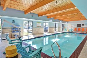 a large swimming pool with blue chairs in a building at Home2 Suites By Hilton Conway in Conway