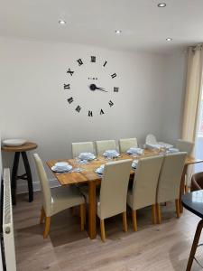 a dining room with a table and a clock on the wall at Richards Retreat Blackpool in Blackpool