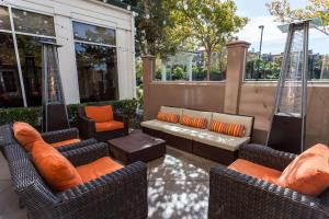 een patio met rieten stoelen en een bank bij Hilton Garden Inn San Mateo in San Mateo