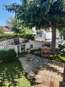 a garden with a table and chairs and a tree at Appartement aux Stes Maries de la Mer in Saintes-Maries-de-la-Mer