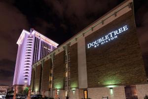 a building with a sign on the side of it at night at DoubleTree by Hilton Montgomery Downtown in Montgomery