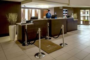 a man standing at a reception desk in a lobby at DoubleTree by Hilton Montgomery Downtown in Montgomery